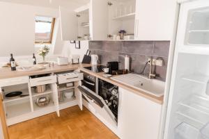 a kitchen with white cabinets and a sink at Cozy Kunsthaus GRAZ in Graz