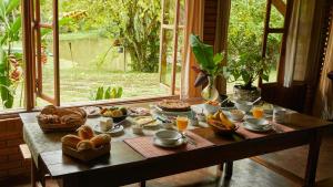 a table with a breakfast of bread and orange juice at Pousada Salve Floresta in Tapiraí