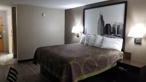 a hotel room with a bed with a large picture on the wall at Super 8 by Wyndham Dickson in Dickson