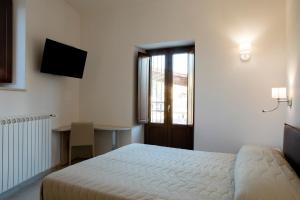 a bedroom with a bed and a desk and a window at Residenza Cappelli - Case Vacanze in San Demetrio neʼ Vestini