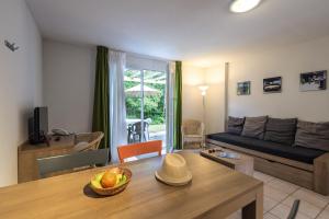 sala de estar con sofá y mesa en Terres de France - Le Domaine Du Golf en Saumur