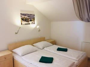 リプノ・ナト・ヴルタヴォウにあるVilla Lanovka Lipno 200のベッドルーム1室(緑のナプキンを添えたベッド2台付)