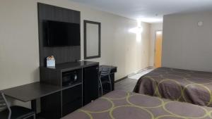 a hotel room with a bed and a flat screen tv at Super 8 by Wyndham Dickson in Dickson