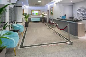 a waiting room with blue chairs and a red carpet at 4R Casablanca Playa in Salou