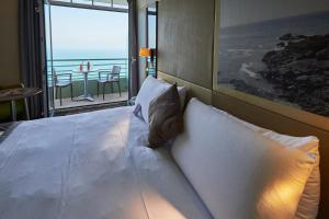een slaapkamer met een bed met uitzicht op de oceaan bij Mercure Granville Le Grand Large in Granville +126 foto's