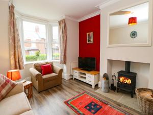 a living room with a red accent wall and a fireplace at Stang View in Barnard Castle