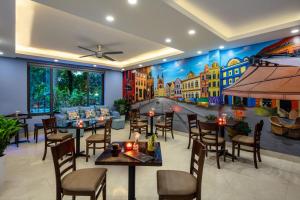 a restaurant with tables and chairs and a painting on the wall at GH Apartment Westlake - Managed by Pegasy Group in Hanoi