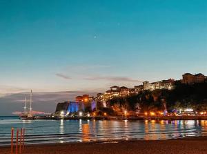 a night view of a city with lights on the water at Apartments Zuto in Ulcinj