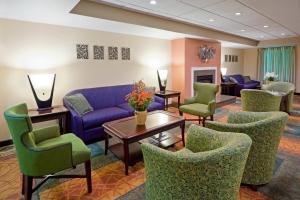 Carneys Point的住宿－新澤西卡尼斯波恩特收費公路1號出口智選假日酒店，一间设有蓝色沙发和绿色椅子的等候室