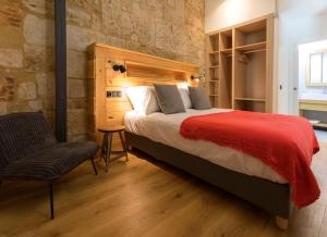 um quarto com uma cama grande e uma cadeira em ERASMUS PLAZA em Salamanca