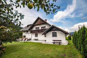 ein weißes Haus mit einer Bank im Hof in der Unterkunft Green Garden Apartments Soklič in Bohinj