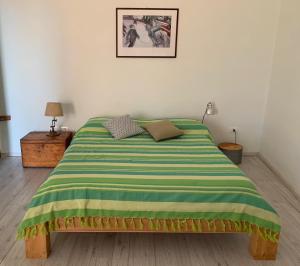 シクリアーナにあるLa scaliaのベッドルーム1室(ベッド1台、緑と黄色の毛布付)