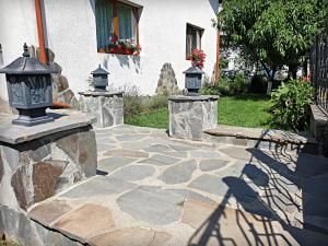 a stone walkway with three lanterns on a house at Dulce Maramures in Ocna Şugatag