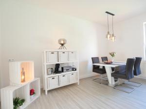 une salle à manger blanche avec une table et des chaises dans l'établissement EUPHORAS - Modern eingerichtete Ferienwohnung mit 3 Schlafzimmern im Harz, à Clausthal-Zellerfeld
