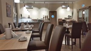 a restaurant with wooden tables and chairs and a counter at Hostel VITA Berlin in Berlin