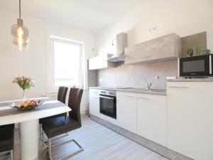 une cuisine blanche avec une table et une salle à manger dans l'établissement EUPHORAS - Modern eingerichtete Ferienwohnung mit 3 Schlafzimmern im Harz, à Clausthal-Zellerfeld 8 autres photos