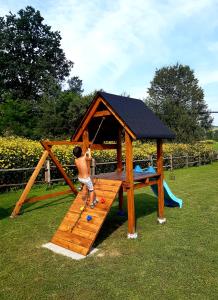 a young boy playing in a wooden play house at Domek Skowronek z basenem in Lesko