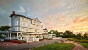 a large building on a street with a sunset at Harbor View Hotel in Edgartown