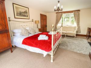 a bedroom with a white bed with a red blanket at Milton Green Farm in Chester