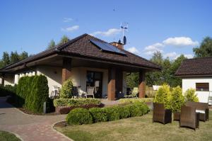 a house with a pitched roof with a patio at Willa Radawka in Dziwnówek