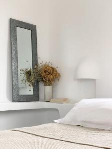 a mirror on a white wall next to a bed at Résidence Les Toits de Santa Giulia in Porto-Vecchio