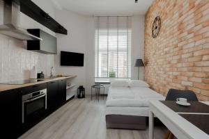 a living room with a white couch and a brick wall at 4 ECO Apart Chateau Jagiellonska 22 Warszawa Old Town in Warsaw