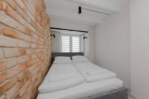 a room with two beds against a brick wall at 4 ECO Apart Chateau Jagiellonska 22 Warszawa Old Town in Warsaw