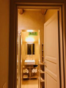 een badkamer met een wastafel, een spiegel en een deur bij Case Graffeo in Menfi