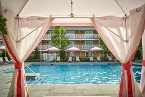 a swimming pool with umbrellas and a hotel at Harbor View Hotel in Edgartown