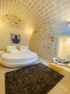 Zimmer mit einem Bett und einer Ziegelwand in der Unterkunft Vacanze in Puglia Monopoli in Monopoli