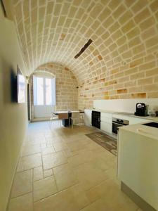 a kitchen with a brick wall and a table at Vacanze in Puglia Monopoli in Monopoli