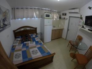 a small bedroom with a bed and a kitchen at The Taras unit in Eilat