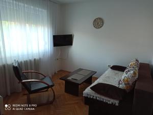 sala de estar con sofá, mesa y silla en Apartman Mima en Banja Luka