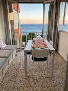 een kamer met een tafel en uitzicht op de oceaan bij Playa/piscina Apto Paraiso Rosa in Benajarafe
