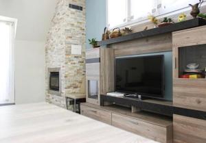 sala de estar con TV y chimenea de ladrillo en La Magnolia Apartments II en Desenzano del Garda