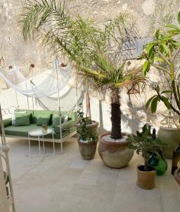 a patio area with a table, chairs, and plants at La Maison in Siracusa