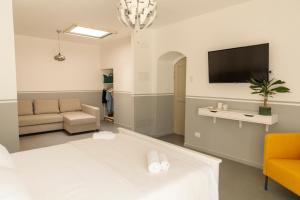 sala de estar con cama y TV de pantalla plana en B&B LA CUPOLA en Catania