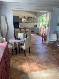 a kitchen and dining room with a table and chairs at Les Romarins in Crestet