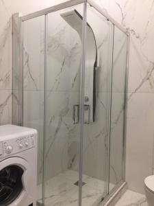 a shower with a glass door next to a washing machine at Patision Avenue, Apartment with Two bedrooms in Athens