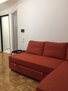 ein Wohnzimmer mit einer roten Couch in einem Zimmer in der Unterkunft Patision Avenue, Apartment with Two bedrooms in Athen