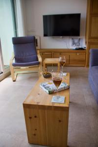 a glass of wine on a coffee table in a living room at Guejar Sierra House with Spectacular Views in Güéjar-Sierra