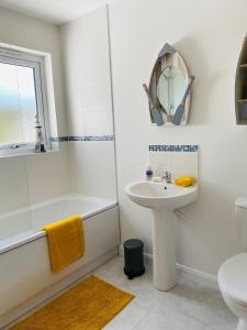 a bathroom with a sink and a tub and a toilet at Oliver's Yard in Helston