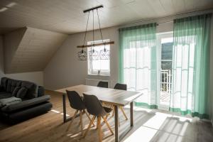 a dining room with a wooden table and chairs at Ferienwohnung Nallenblick in Gersfeld