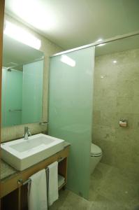 a bathroom with a sink and a toilet and a mirror at Keumho Jeju Resort in Seogwipo