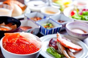 una mesa con platos de comida y cuencos de diferentes alimentos en La Vista Hakodate Bay, en Hakodate