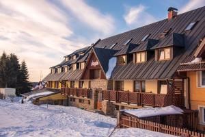 ein großes Haus mit Schnee auf dem Boden in der Unterkunft Apartmány Engadin in Boží Dar