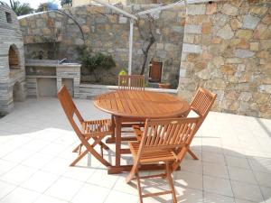 a wooden table and chairs sitting on a patio at Gites-Sassone in Sagone