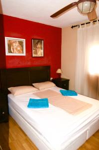 1 dormitorio con 1 cama blanca grande y pared roja en Playa Rosa Valencia, en Valencia