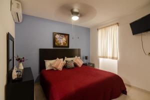 - une chambre avec un lit rouge et une couverture rouge dans l'établissement El Rincon de Los Angeles, à Colima