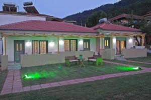 una casa con luces verdes en el patio en Annmari Studios en Skála Potamiás